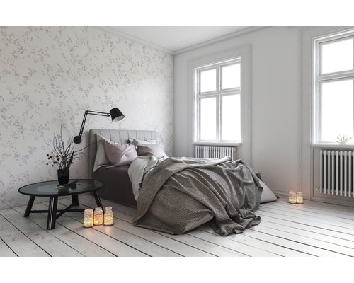 Spálňa s posteľou, nočným stolíkom a kvetinovou tapetou