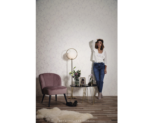 Obývacia izba s kreslom, príručným stolíkom a stojacou lampou pred vzorovanou stenou