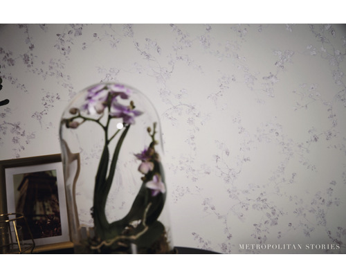 Detail steny s kvetinovou tapetou a orchideou pod skleneným poklopom.