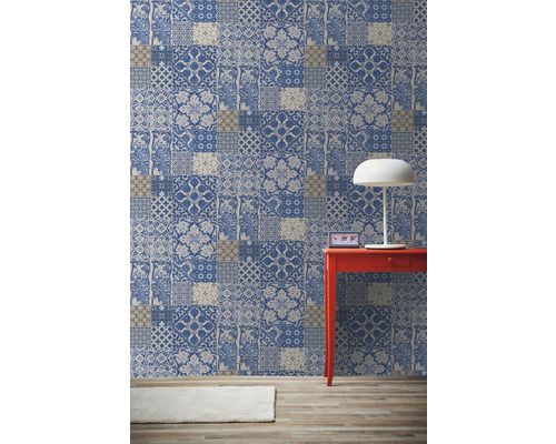 Izba s vzorovanou tapetou v štýle patchwork, červeným stolom a lampou