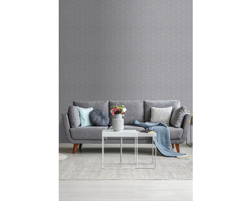 Obývacia izba so sivou vzorovanou tapetou, pohovkou, kobercom a stolom