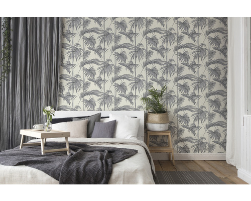 Spálňa s posteľou a tapetou s motívom paliem