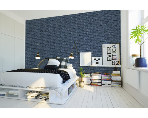 Spálňa s posteľou pred stenovou tapetou s motívom tehál