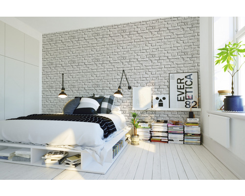 Spálňa s posteľou, nočným stolíkom a tapetou s tehlovým vzorom