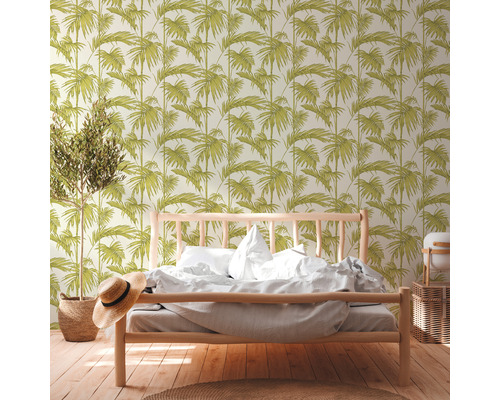 Spálňa s posteľou a tapetou s listovým vzorom.