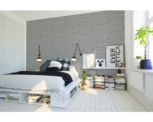 Svetlá spálňa s posteľou a sivou tapetou s motívom tehál