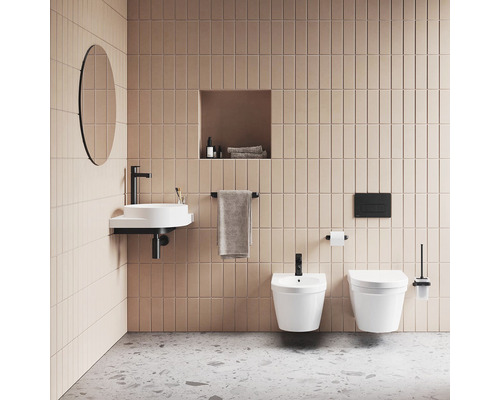 Kúpeľňa s umývadlom, zrkadlom, toaletou a bidetom pred obloženou stenou