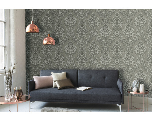 Obývacia izba so sivou damaškovou tapetou, pohovkou a medenými lampami