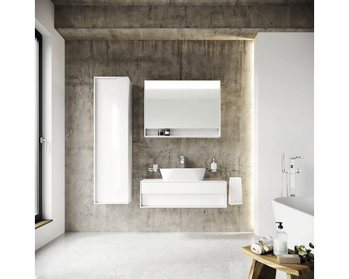 Moderná kúpeľňa s bielym umývadlom, zrkadlovou skrinkou a vysokou skriňou pred betónovou stenou