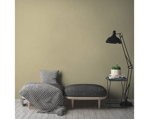 Dekoratívne obytné prostredie s posedením, stojacou lampou a izbovou rastlinou na odkladacom stolíku pred jednofarebnou stenou