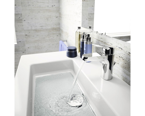 Moderná kúpeľňa s umývadlom, batériou a kozmetickými produktmi