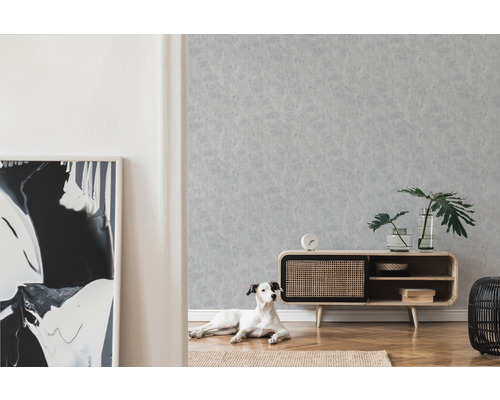 Obývacia izba so vzorovanou tapetou, príborníkom a psom