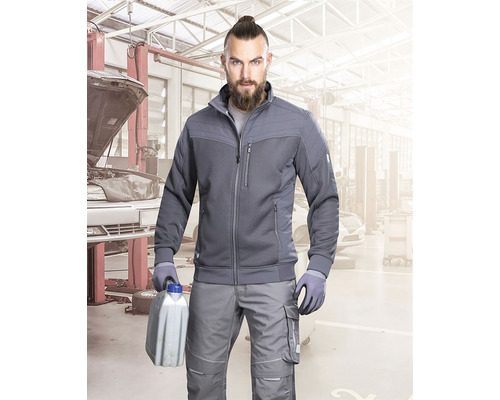 Muž v pracovnom odeve drží kanister v dielni