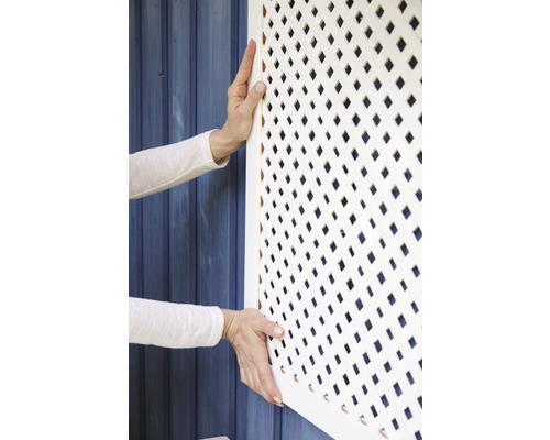 Osoba montuje bielu mriežku