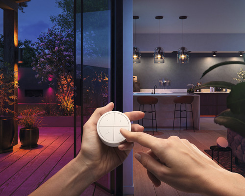 Scéna s osobou ovládajúcou vypínač svetla pred osvetlenou terasou a vnútornou kuchyňou