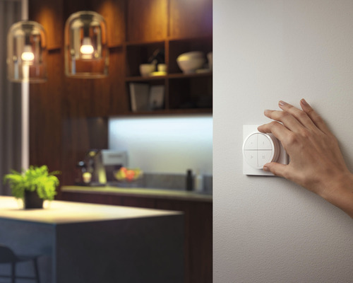 Ruka ovláda vypínač svetla v moderne zariadenej izbe.