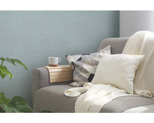 Obývacia izba s pohovkou, vankúšmi a vzorovanou tapetou