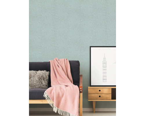 Obývacia izba s tapetou so vzorom, pohovkou, vankúšom, dekou a komodou