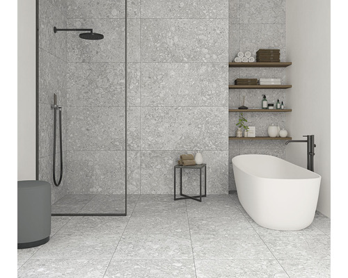Moderná kúpeľňa so sivou kameninovou dlažbou, sprchou a voľne stojacou vaňou.