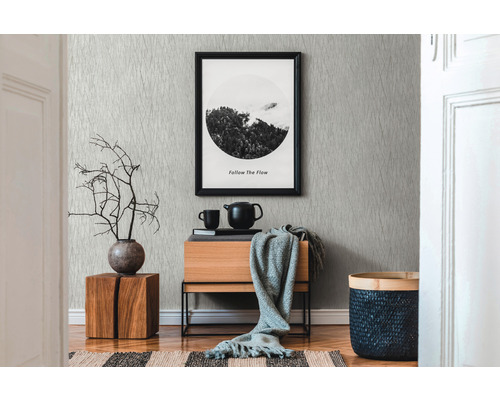 Obývacia izba so vzorovanou tapetou, drevenou komodou a dekoratívnymi prvkami