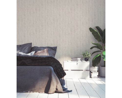 Spálňa s posteľou, nočným stolíkom a izbovými rastlinami pred štruktúrovanou tapetou