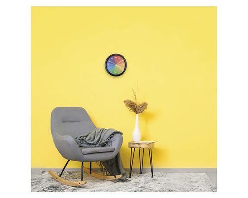 Obývacia izba s hojdacím kreslom, nástennými hodinami a odkladacím stolíkom pred žltou stenou