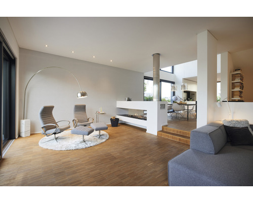 Svetlý obývací priestor s krbom, kreslami a stojacou lampou