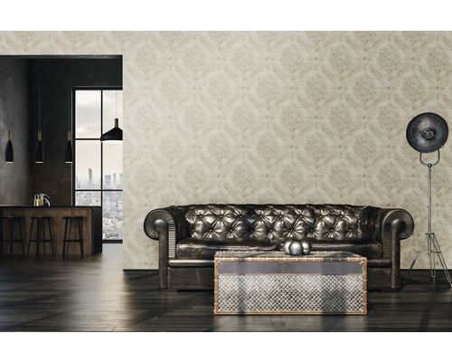 Obývacia izba so vzorovanou tapetou, koženou pohovkou, stolom a stojacou lampou