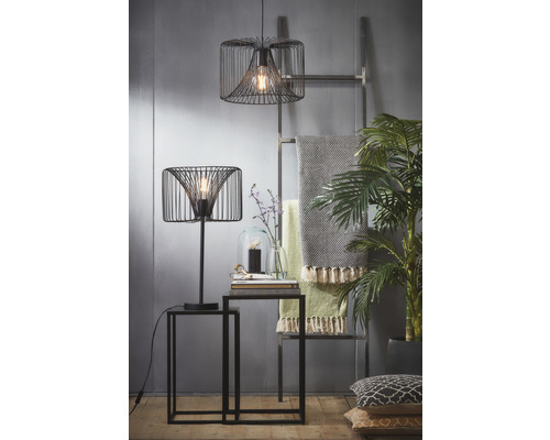 Dekoratívny interiér so stolnou lampou, závesnou lampou, dvoma príručnými stolíkmi, rebríkom, dekou a izbovými rastlinami.