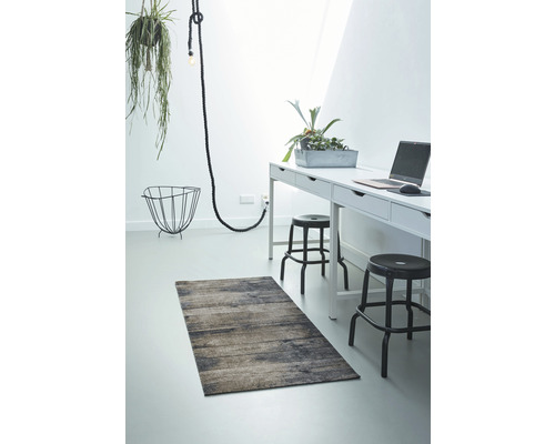 Príklad usporiadania s kobercom, písacím stolom a dekoráciami vo svetlej miestnosti.