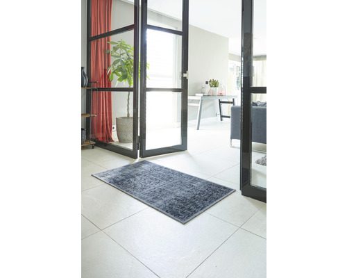 Dekoratívny koberec v chodbe domu na dlažbe.