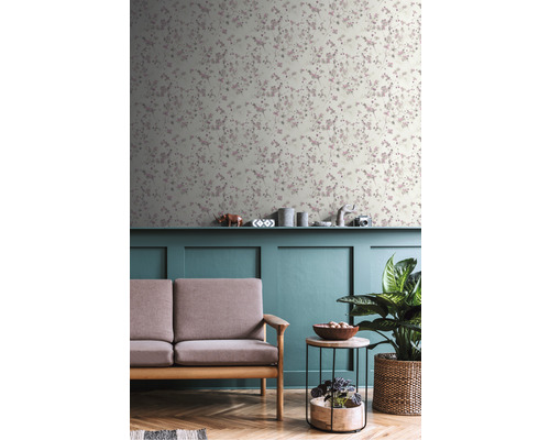 Obývacia izba s kvetinovou tapetou, pohovkou, stolom a izbovou rastlinou