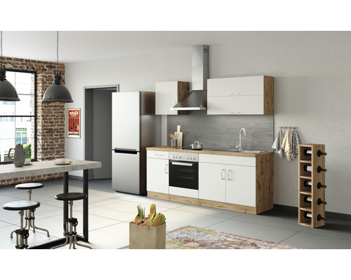 Moderná kuchyňa so vstavanými spotrebičmi, jedálenským stolom a barovými stoličkami vo svetlej miestnosti.