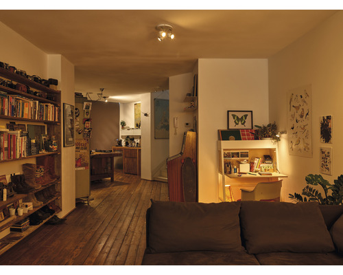 Pohľad do obývacej izby s knižnicou, písacím stolom a drevenou podlahou