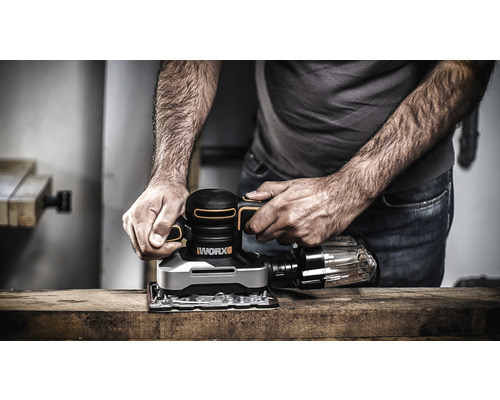 Muž brúsi drevenú dosku excentrickou brúskou WORX