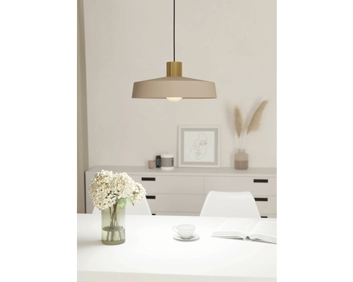 Béžová závesná lampa nad jedálenským stolom v svetlej miestnosti.