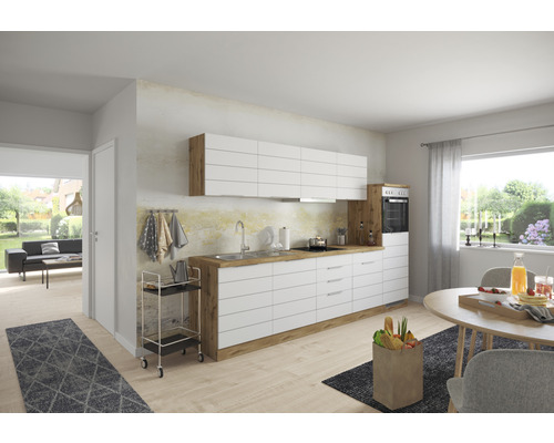 Moderná kuchyňa s bielymi skrinkami, drevenými detailmi a jedálenským stolom vo svetlej miestnosti.