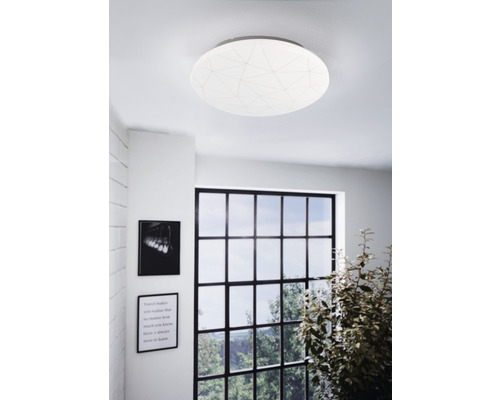 Okrúhle stropné svietidlo s geometrickým vzorom v obývacej izbe.
