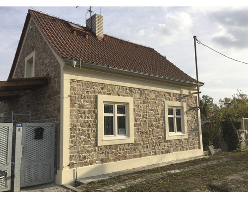 Fasáda domu s kamenným obkladom a sedlovou strechou