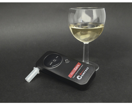 Digitálny alkohol tester s pohárom bieleho vína
