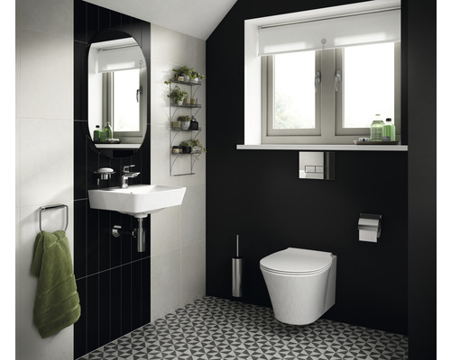 Svetlá kúpeľňa s umývadlom, zrkadlom, toaletou a geometrickým vzorom podlahy