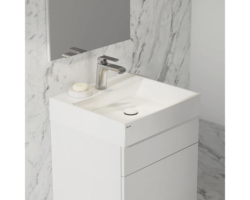 Biele umývadlo s umývadlom, batériou a zrkadlom pred mramorovou stenou