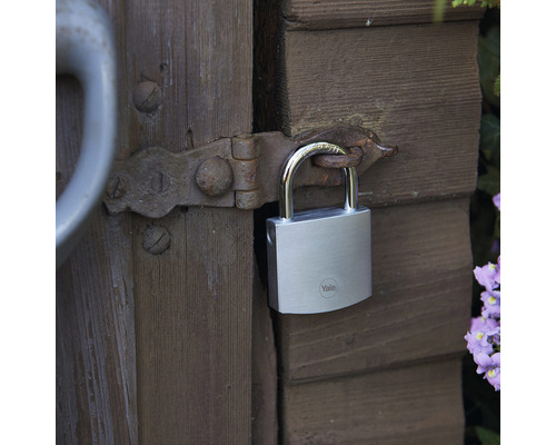 Visiaci zámok Yale Logo na drevených dverách