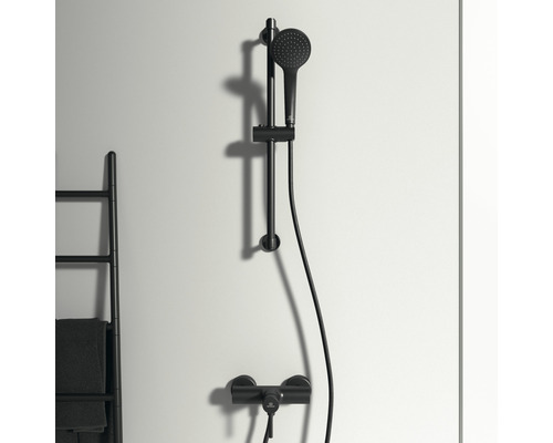 Sprchová súprava s tyčou a ručnou sprchou pred stenou
