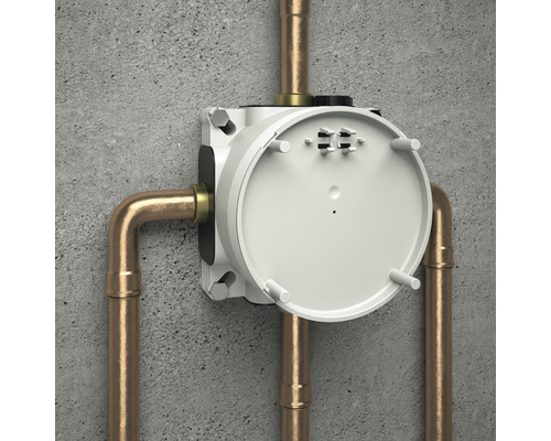 Podomietkové teleso s medenými rúrkami na betónovej stene