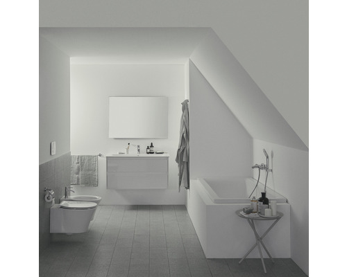 Svetlá kúpeľňa s vaňou, umývadlom a toaletou v podkroví.