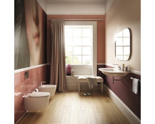 Kúpeľňa s toaletou, bidetom, umývadlom, zrkadlom a oknom pre svetlú atmosféru.