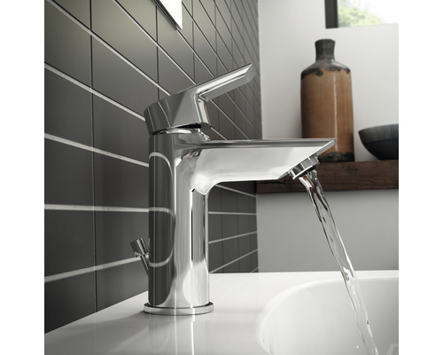 Lesklá kovová vodovodná batéria v kúpeľni s tečúcou vodou