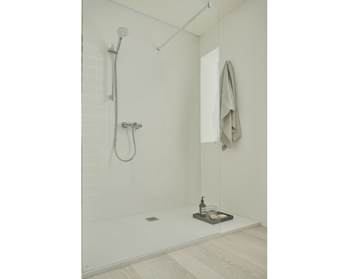 Sprchovací kút v úrovni podlahy so sklenenou zástenou, armatúrou a uterákom