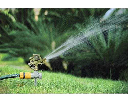 Zavlažovač trávnika zavlažuje trávnik v záhrade.